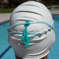 Sea foam green orca shaped Swim Loops goggle tag to label swim goggles  attached to swim goggles on swimmers head