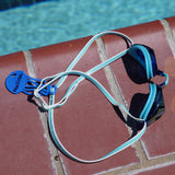 Blue jellyfish Swim Loops goggle tag with name written on it attached to swim goggles next to swimming pool
