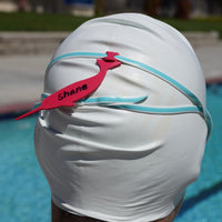 Dark pink narwhal shaped Swim Loops goggle tag to label swim goggles attached to swim goggles on swimmers head