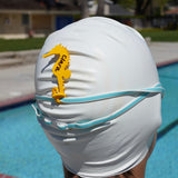 Yellow seahorse shaped Swim Loops goggle tag to label swim goggles attached to swim goggles on swimmers head