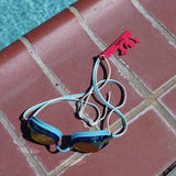 Dark pink Drowning Daryl shaped Swim Loops goggle tag for labeling swim goggles attached to swim goggles next to pool